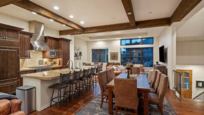 A spacious kitchen with granite countertops, dark wooden cabinets, and a stainless steel range hood.
