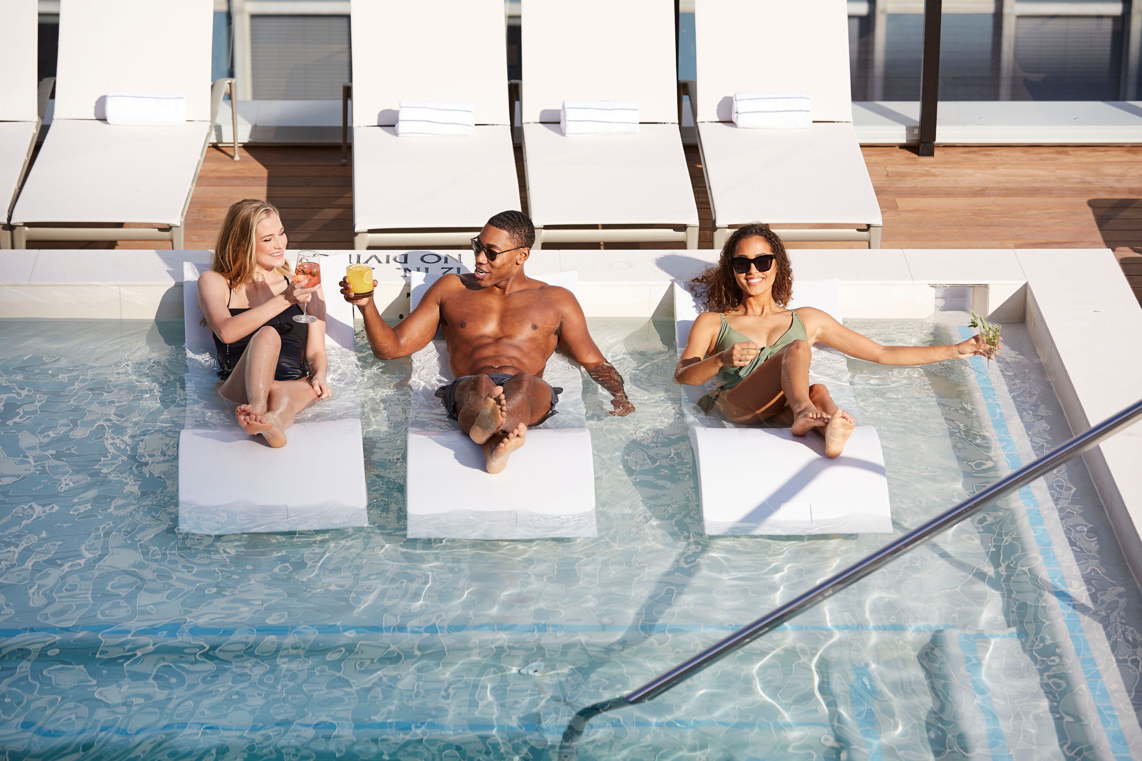 A pool area with lounge chairs and a hot tub.