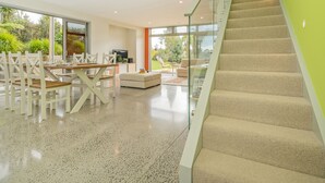 Un intérieur moderne comprenant un coin repas, un canapé et un escalier.