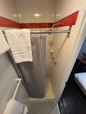 Quarto solteiro básico | Banheiro | Produtos de toalete de grife, secador de cabelo, toalhas de banho 