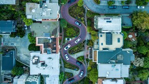 An aerial view of a residential area with winding roads, houses, and greenery. - Touchstone Hotel - City Center (San Francisco)