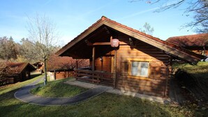 A wooden cabin with a porch, a window, and a door. - Blockhaus Noffke (Stamsried)