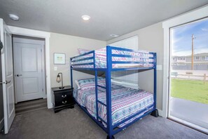Dormitorio con literas y vista al exterior: zona verde y edificios.