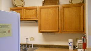 A kitchen with wooden cabinets, a dishwasher, a sink, and a coffee maker.