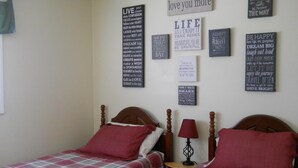 A bedroom with two beds, each with a plaid bedspread and red pillows. There are motivational posters on the wall. - Sugar Ski & Country Club Unit 436 Silver (Banner Elk)