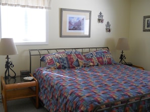 A bedroom with a bed, two bedside lamps, a bedside table, a framed picture on the wall, and a window with blinds. - Sugar Ski & Country Club Unit 436 Silver (Banner Elk)