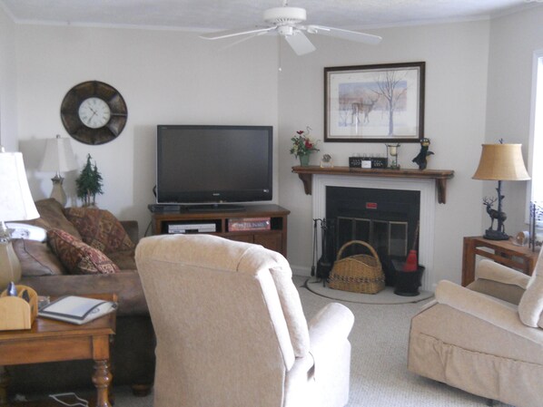 A living room with a television, sofa, armchair, fireplace, and a ceiling fan. - Sugar Ski & Country Club Unit 535 Silver (Banner Elk)