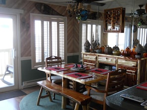 A dining area with a wooden table, benches, and a decorative cabinet with glassware. - Sugar Ski & Country Club Unit 821 Gold (Banner Elk)