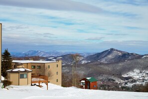 A hotel with a snow-covered deck and a view of mountains. - Sugar Ski & Country Club Unit 414 Silver (Banner Elk)