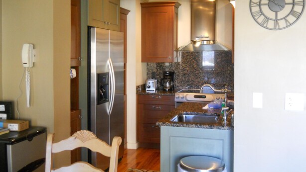 Una cocina compacta equipada con refrigerador, estufa y cafetera.
