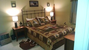A bedroom with a bed, two bedside lamps, a nightstand, a rug, and a framed picture on the wall. - Sugar Ski & Country Club Unit 832 Silver (Banner Elk)