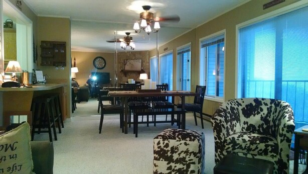 A spacious living room with a dining area, large windows, and a ceiling fan. - Sugar Ski & Country Club Unit 832 Silver (Banner Elk)