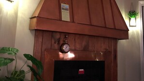 A fireplace with a clock above it, flanked by two wall-mounted lights and a framed picture. - Sugar Ski & Country Club Unit 811 Gold (Banner Elk)