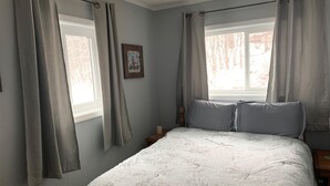 A bedroom with a bed, two windows, and a nightstand. - Sugar Ski & Country Club Unit 125 Silver (Banner Elk)