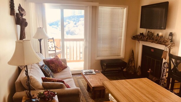 Ein gemütliches Wohnzimmer mit einer Couch, einem Couchtisch, einer Lampe und einem Kamin.