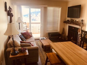 Una sala de estar acogedora con sofá, mesa de centro, lámpara y chimenea.