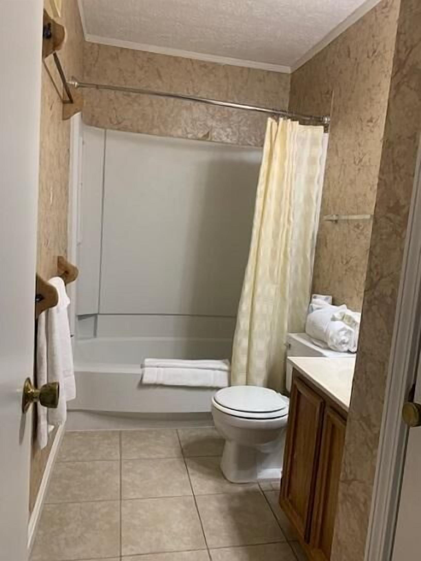 A bathroom with a bathtub, toilet, and sink.