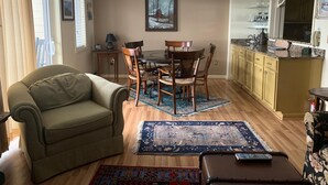 A living room with a sofa, a dining table with chairs, a kitchen area with cabinets, and a ceiling fan. - Sugar Ski & Country Club Unit 433 Gold (Banner Elk)