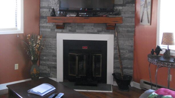 A living room with a fireplace, a television mounted above it, and a small table with a lamp. - Sugar Ski & Country Club Unit 511 Gold (Banner Elk)