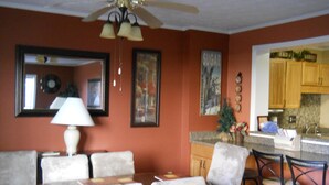 A dining area with a table and chairs, a ceiling fan, and a kitchen area with wooden cabinets and a sink. - Sugar Ski & Country Club Unit 511 Gold (Banner Elk)