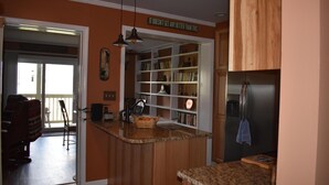 A kitchen with wooden cabinets, a granite countertop, and a built-in bookshelf. - Sugar Ski & Country Club Unit 615 Platinum (Banner Elk)