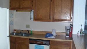 A kitchen with wooden cabinets, a dishwasher, a coffee maker, and a sink. - Sugar Ski & Country Club Unit 822 Silver (Banner Elk)