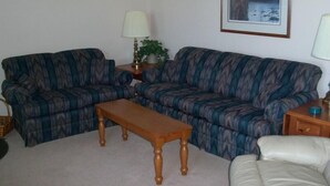 A living room with a sofa, a wooden coffee table, and a lamp. - Sugar Ski & Country Club Unit 822 Silver (Banner Elk)