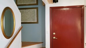 A staircase with wooden steps and a red door at the bottom. - Sugar Ski & Country Club Unit 11-403 Gold (Banner Elk)
