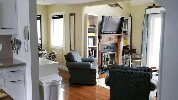 A spacious living area with hardwood flooring, a grey sofa, a television, and a bookshelf. - Sugar Ski & Country Club Unit 11-403 Gold (Banner Elk)