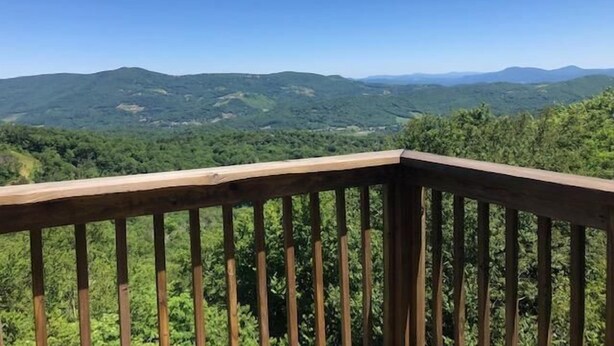 Eine Holzterrasse mit Blick auf eine Berglandschaft.