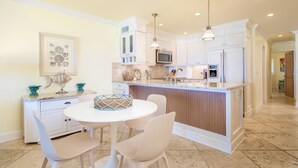 Una cocina moderna con armarios blancos, una isla central e iluminación colgante.