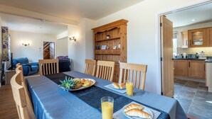 A dining area with a table set for breakfast, including croissants, fruit, and juice. - Old Alton Hall Farmhouse (Holbrook, near Ipswich)