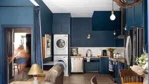 Een moderne keuken met een wasmachine, vaatwasser en een eethoek met een tafel en stoelen.