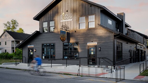 Een gebouw met een bord waarop staat 'Barn Burner Events, Lodging & More' en een 'Service' deur.