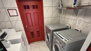 A laundry room with a red door, two washing machines, and a dryer. - 14 on the Ridge, Pet Friendly! (Pigeon Forge)