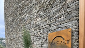Un muro de piedra con un cartel que dice 'CASA DO ARCO'.