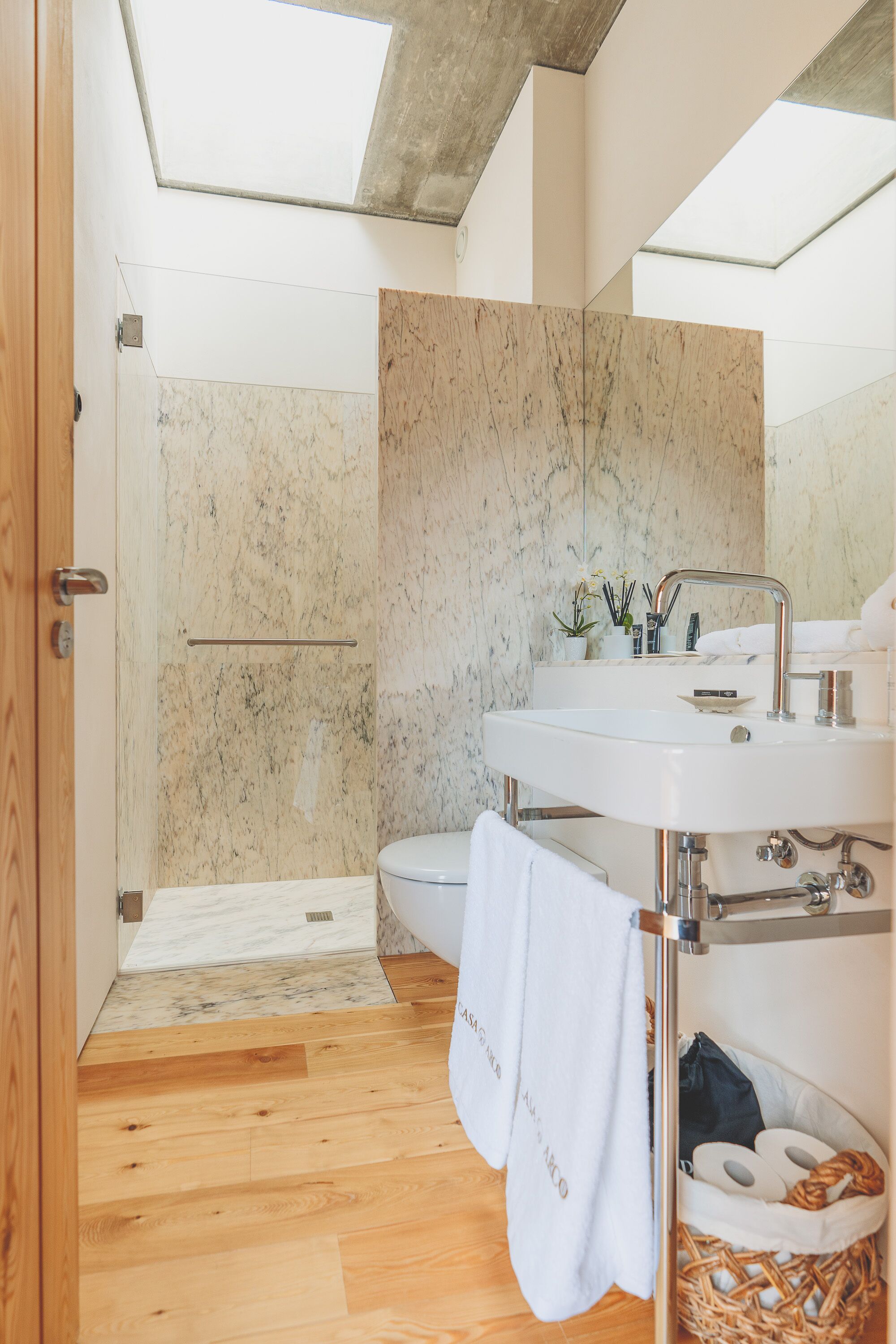 A modern bathroom with a shower, toilet, and sink.
