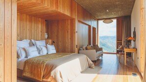 Una habitación de madera con una cama, un sofá y una mesa de comedor.