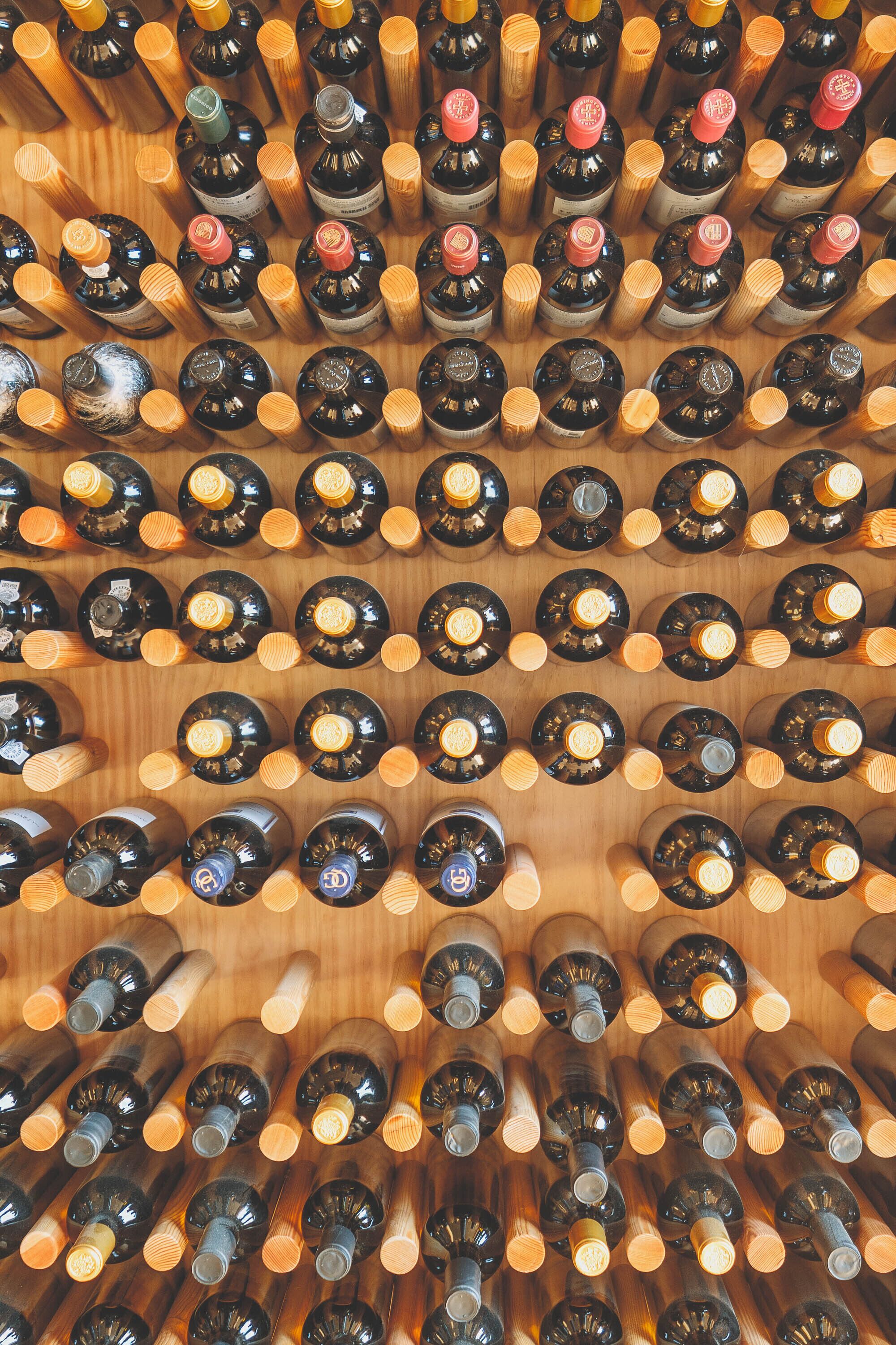 Una bodega con varias botellas dispuestas en filas.