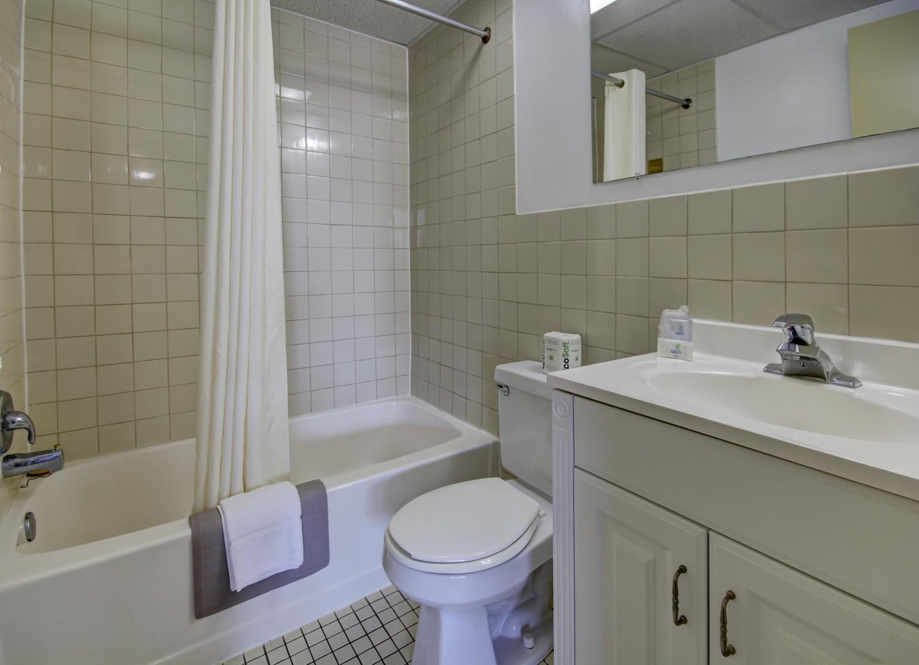 A bathroom with a bathtub, toilet, and sink.