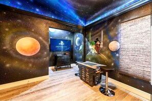 Experience the cosmos in this space-themed room with a large wall mural, flat-screen TV, and desk area.