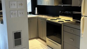 Eine moderne Küche mit Edelstahlgeräten, weißen Schränken und Holzboden.