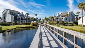 Zona residencial frente al agua, con casas modernas, un muelle de madera y una masa de agua tranquila.