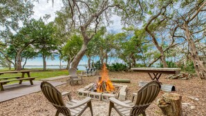 An outdoor seating area with a fire pit, picnic tables, and chairs. - Vilano Beach (St. Augustine)