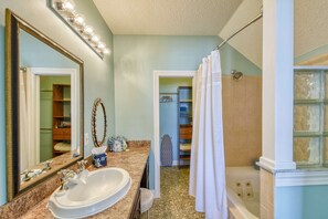 Casa de banho com lavatório, espelho, toucador, chuveiro e closet.