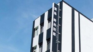 Un edificio moderno con un letrero vertical que indica que es un hotel B&B.