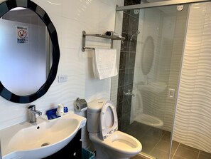 A bathroom with a sink, toilet, and a glass-enclosed shower. - Spring Hall (Luye)