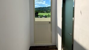 A white door with a view of a green landscape and a clear sky. - Spring Hall (Luye)