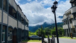 A building with a paved walkway, a parked car, and a street lamp. - Spring Hall (Luye)