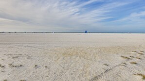 A wide, open sandy beach with a distant blue lifeguard tower. - Beachfront Siesta Key Condo w/ Enclosed Patio (Siesta Key)